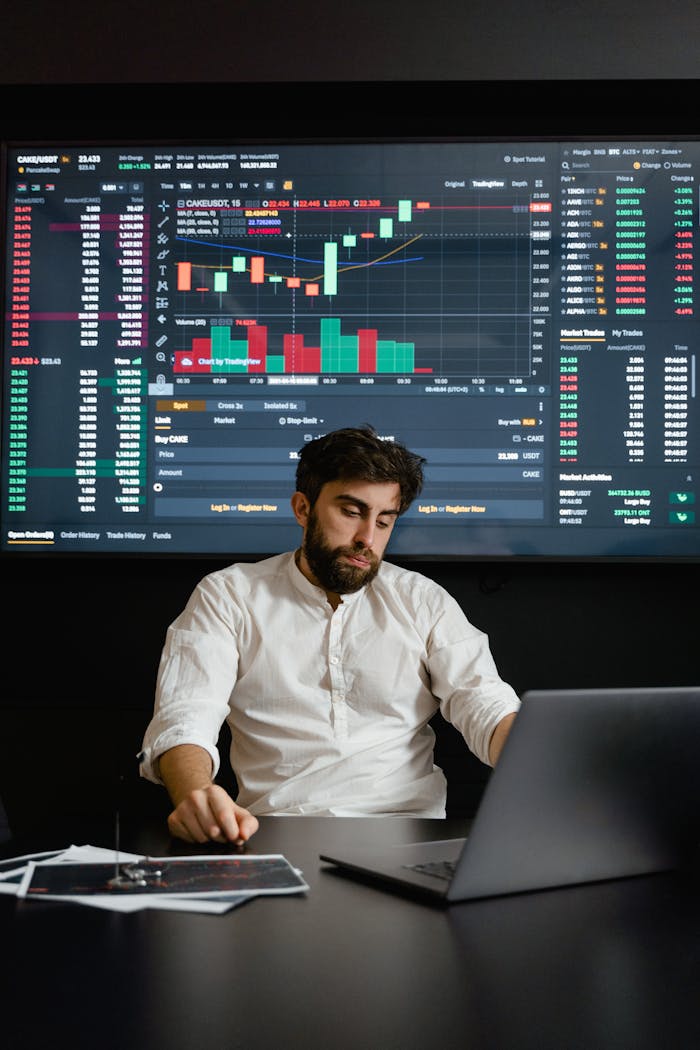 Focused man working on cryptocurrency trading with charts displayed in office.